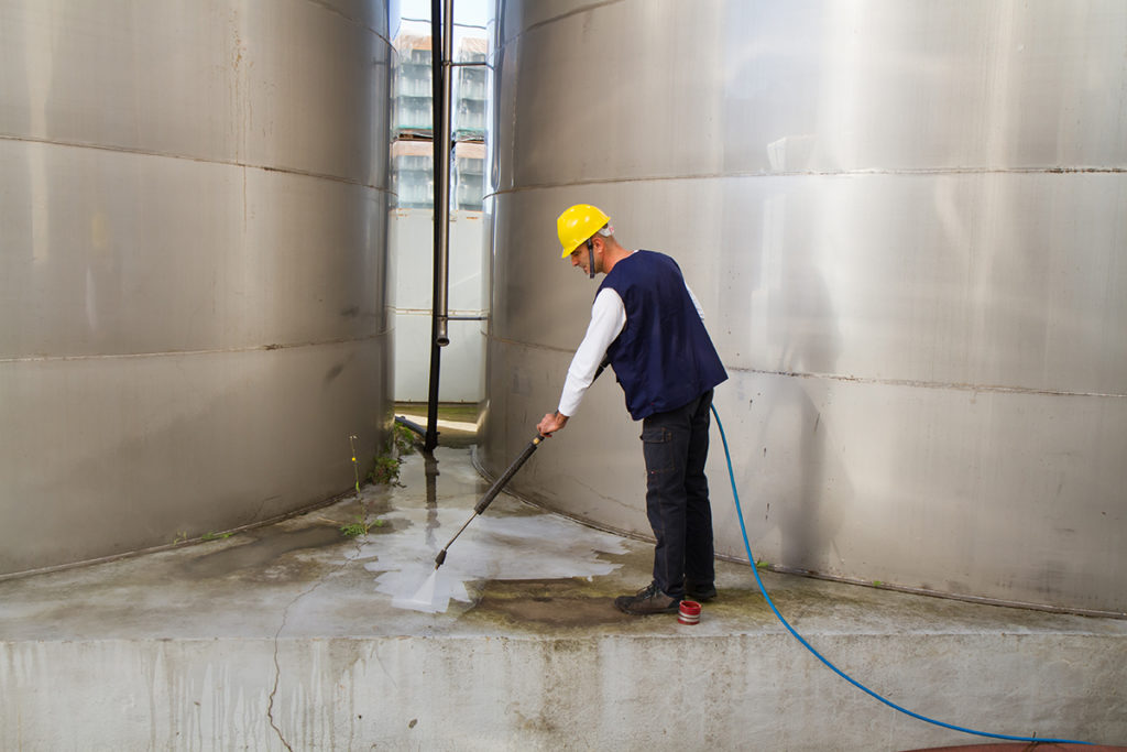 Man Pressure Washing Concrete